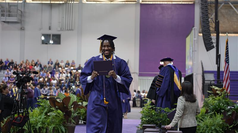 Fall Commencement 2025 Walking Grad Student walking off the commencement stage after receiving diploma