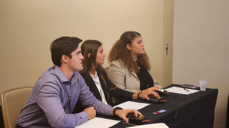 Three students competing in an agricultural economics quiz bowl 