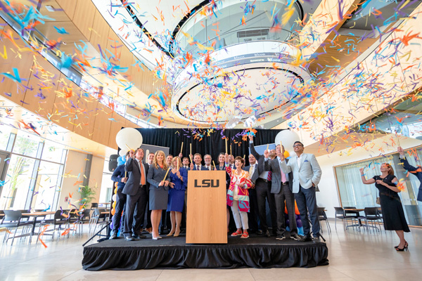 A large group of people on a stage confetti falling around them. 