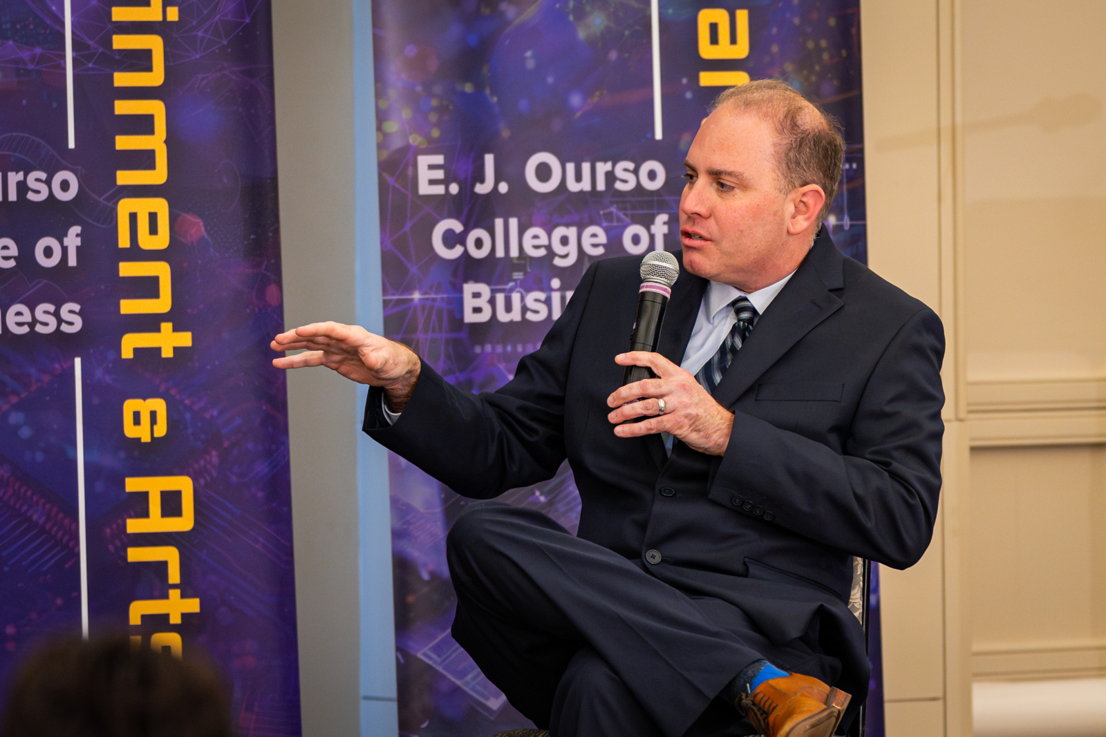 Andrew Schwartz speaking on stage at AI Symposium