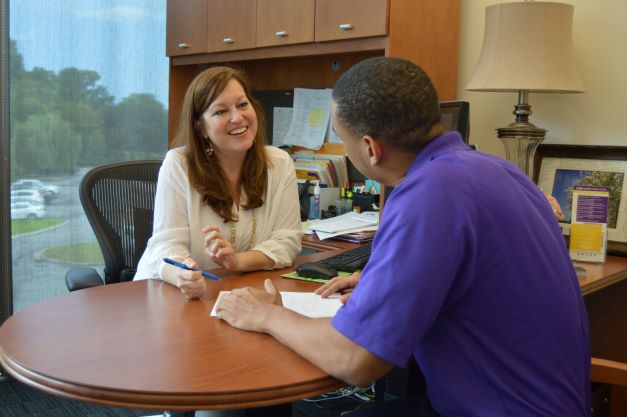 Female counselor meets with student in office. 