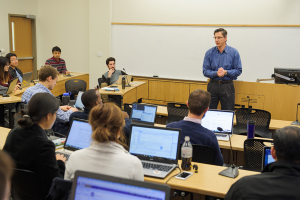 male instructors speaks in front of classroom of students