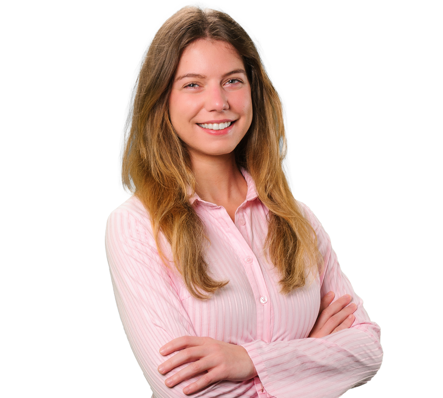 Karly Robledo is in a pink shirt smiling for a photo with her arms crossed.