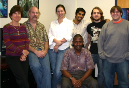 Seven people pose for a photo indoors