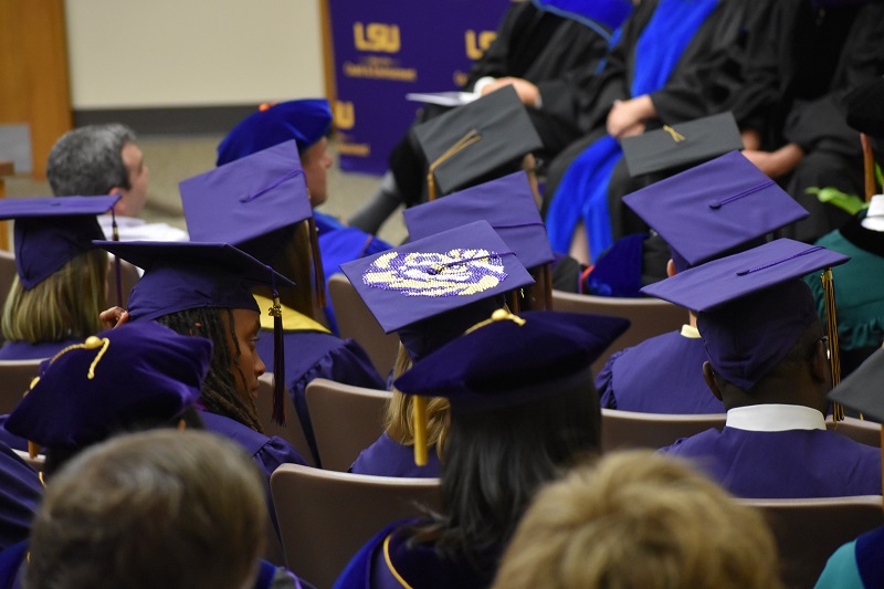 image of a sea of graduation cap; one has a bedazzled tiger eye on it