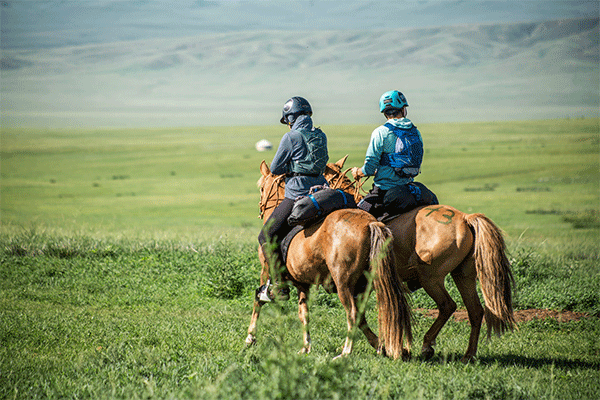 Dr. Kerry Pride and Buckshot Nelson riding horses in Mongolia